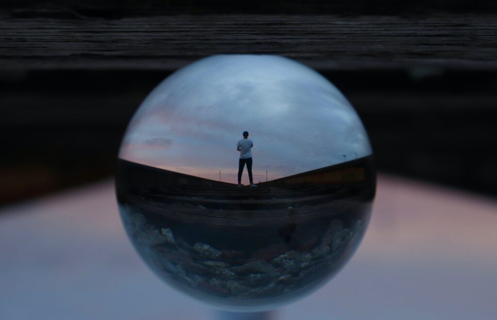 reflection of man on a journey in glass ball